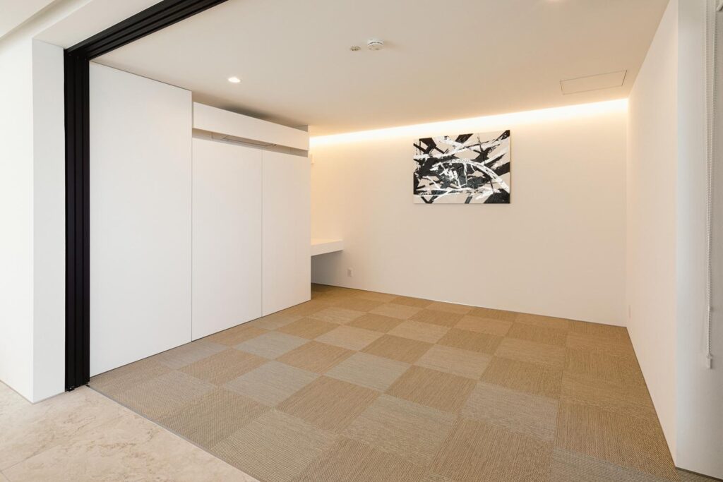 シンプルで明るいフリールーム。壁に抽象的なアートが飾られている。