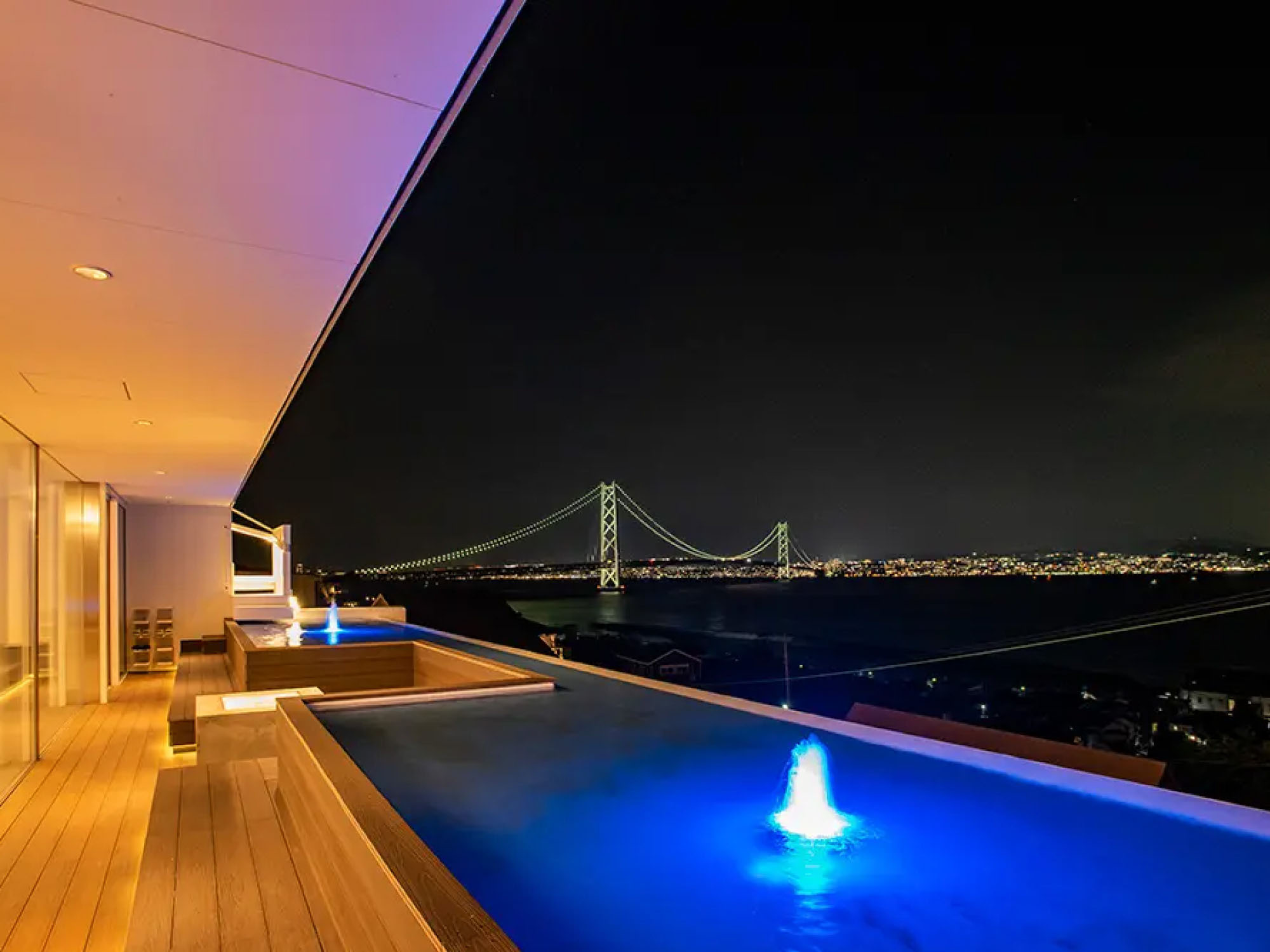 夜の淡路島ヴィラから見えるライトアップされた明石海峡大橋とプール