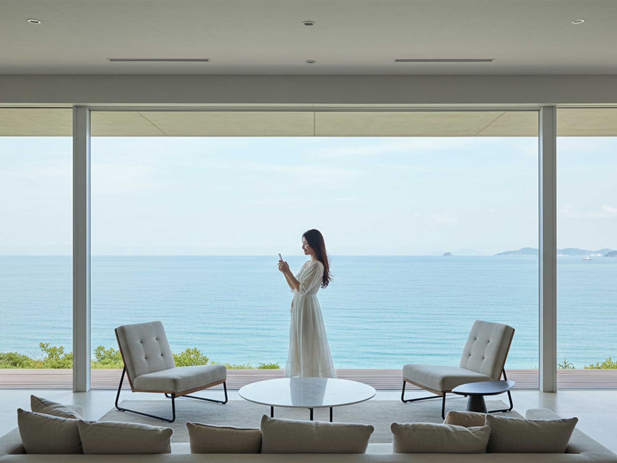 海を見渡すパノラマ窓のリビングで過ごす淡路島ヴィラ