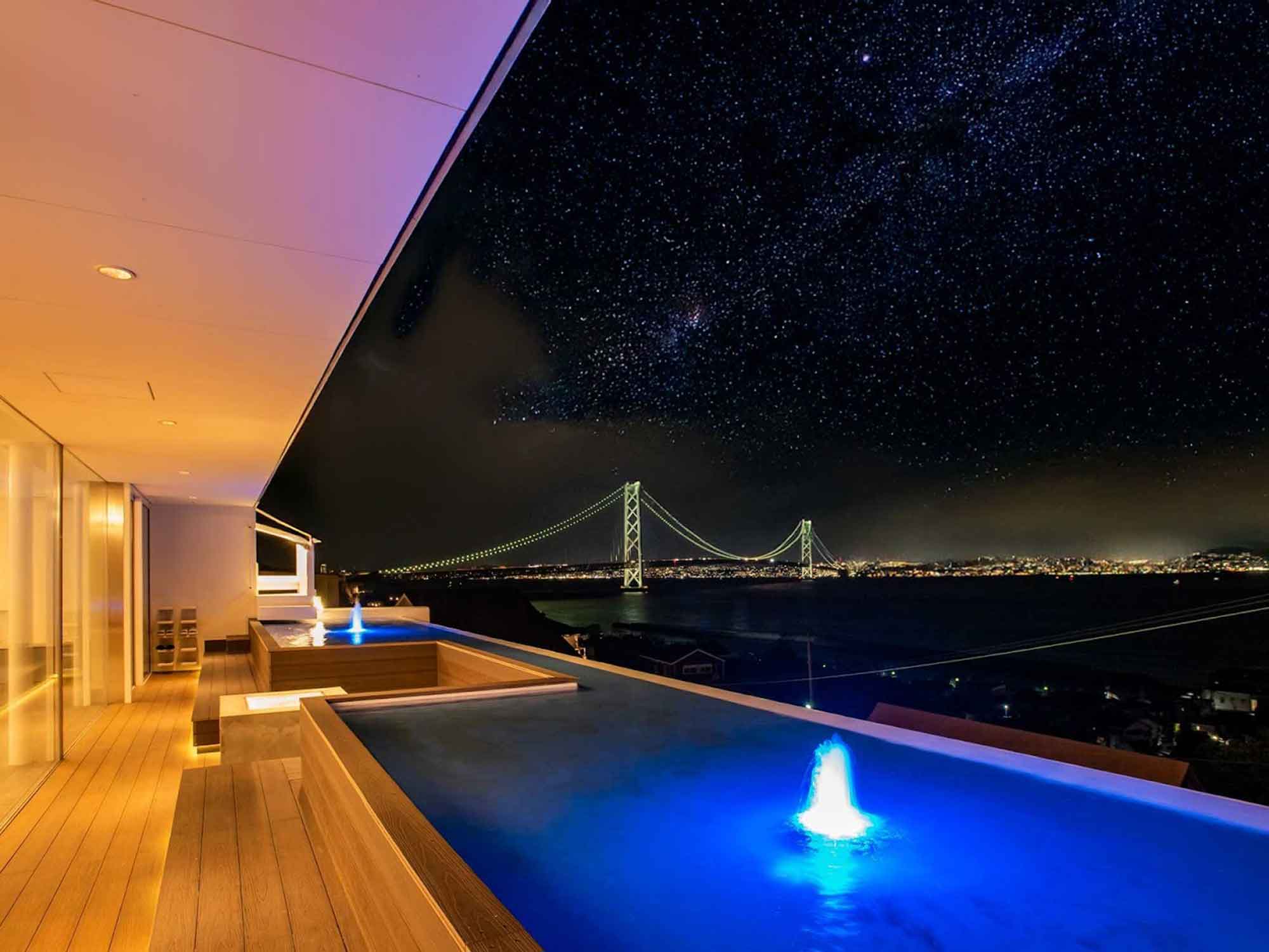 南あわじ市の一棟貸しヴィラのインフィニティ風テラスから望む星空と明石海峡大橋。カップルで楽しむ星空観賞の特別な夜。